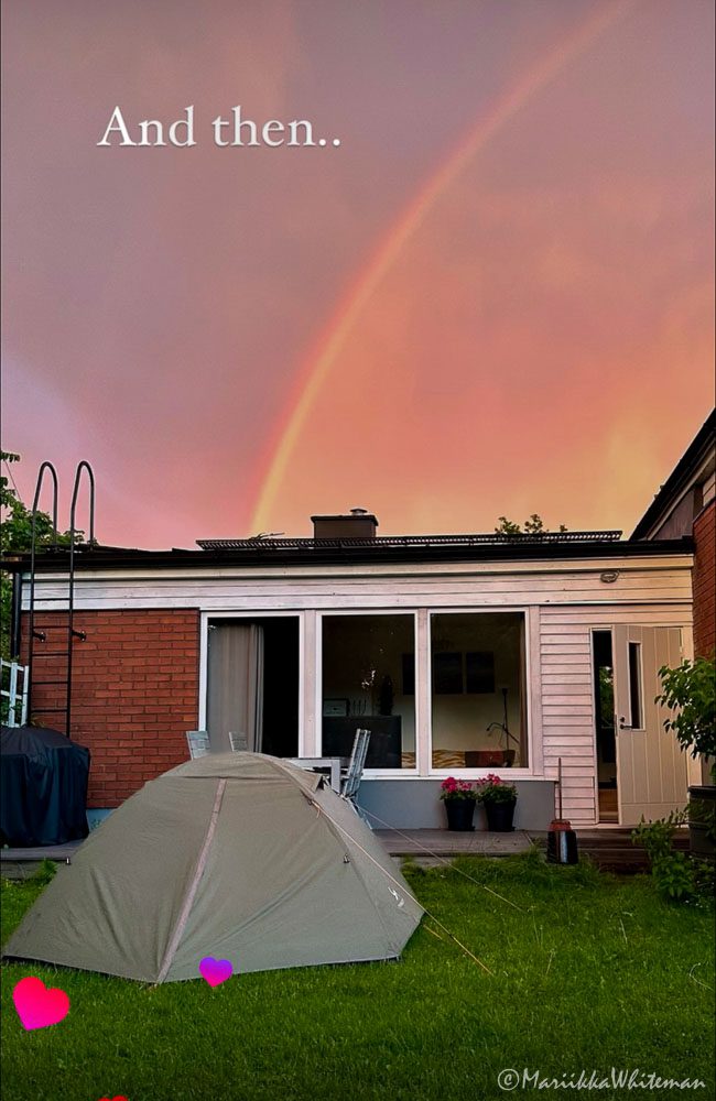 Rainbow over a house and tent